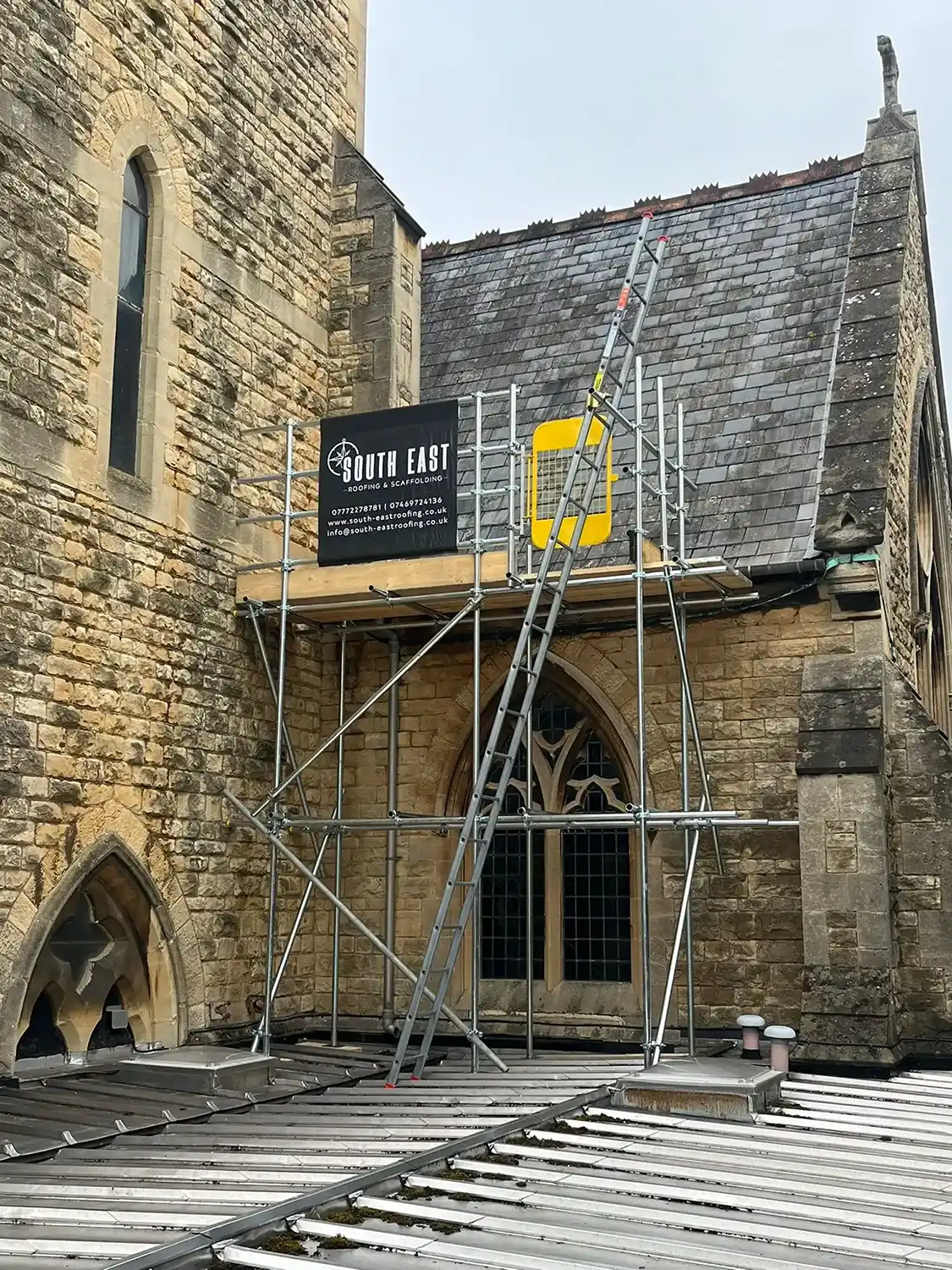 A building with a scaffold and a sign on it.