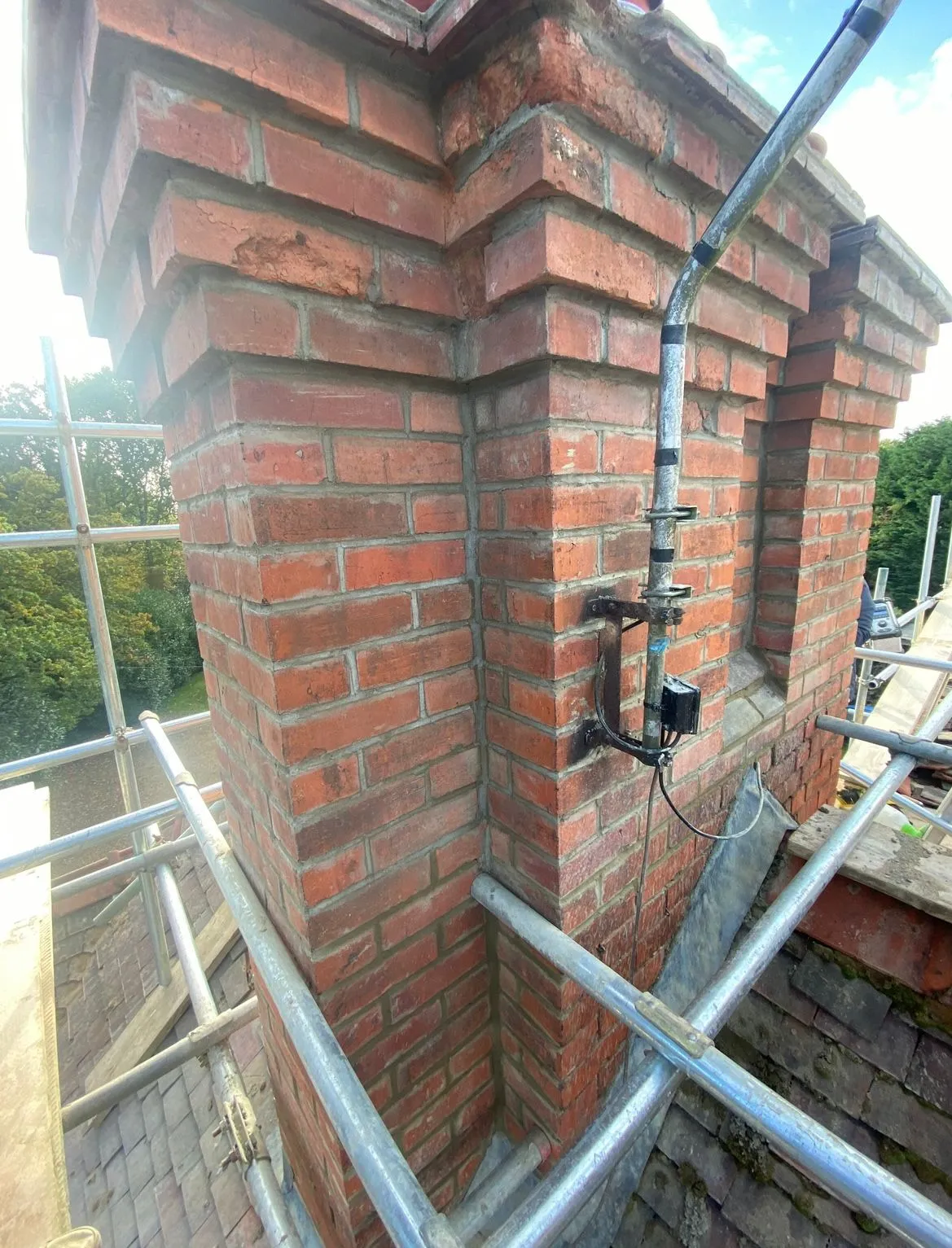 A brick chimney being installed on top of a building.
